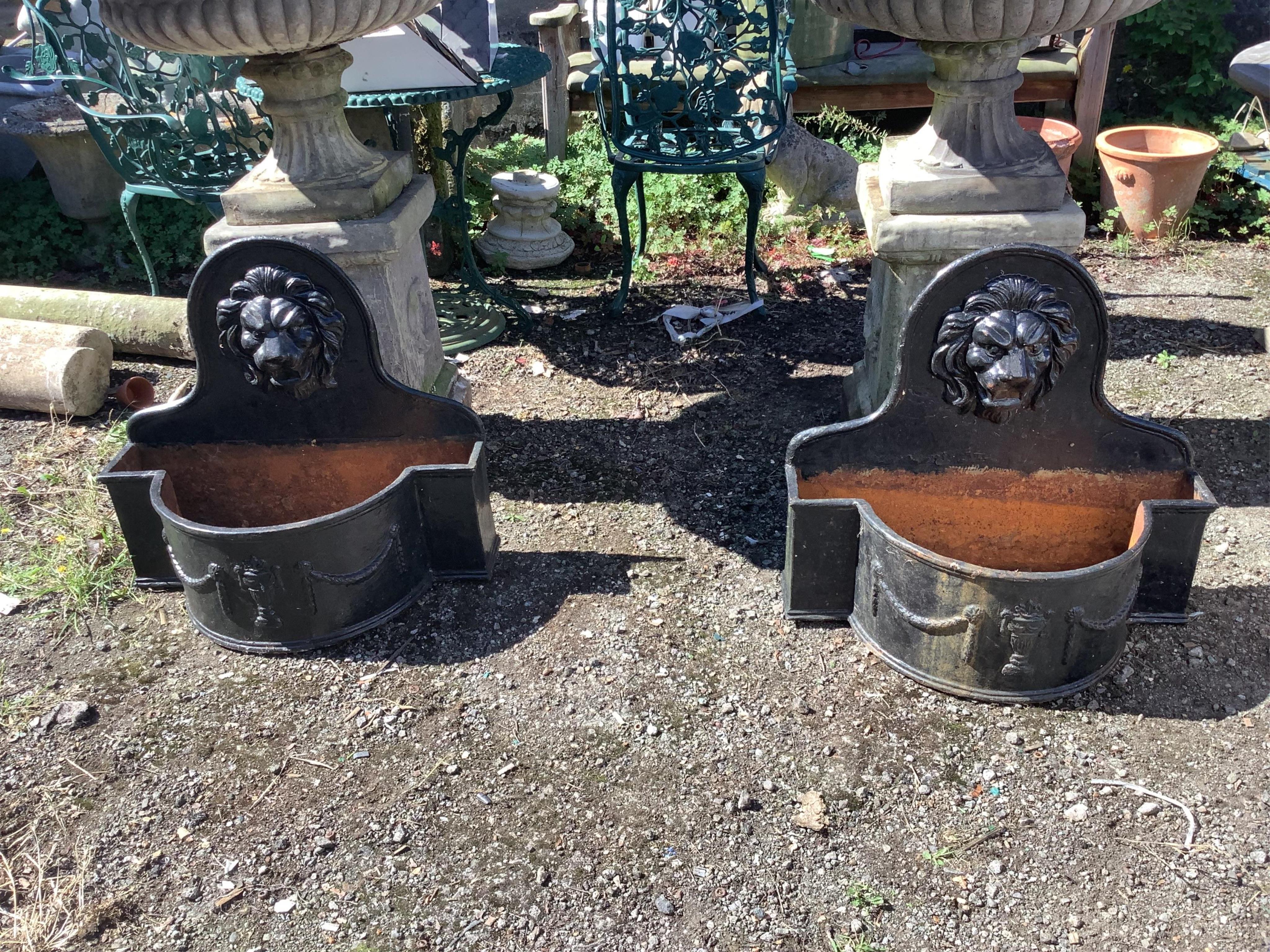 A pair of cast iron lion mask bowfront garden planters, width 69cm, height 65cm. Condition - fair